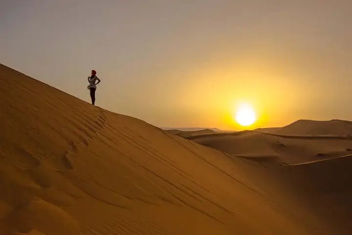 Traveller watching the sunrise from a dune