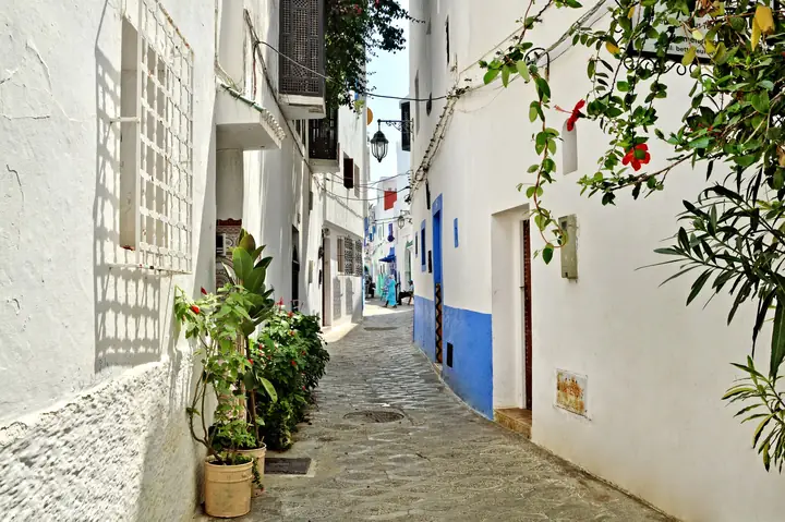 Via imbiancata a calce con dettagli blu ad Asilah