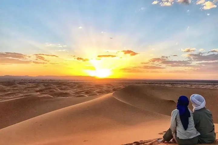 Coppia che contempla il tramonto sulle dune di Merzouga