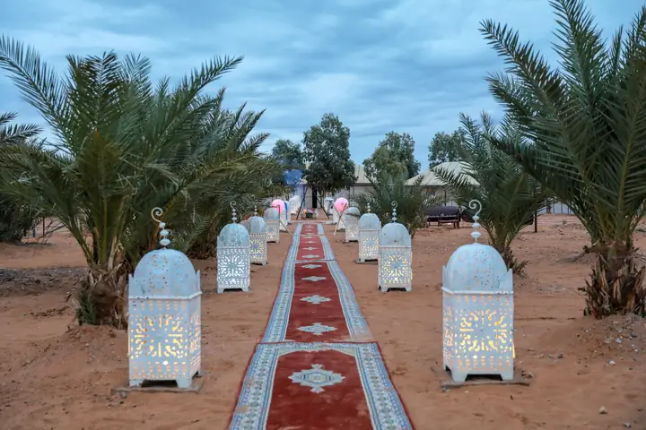 Entrance with lanterns and rugs at a camp in Erg Chebbi