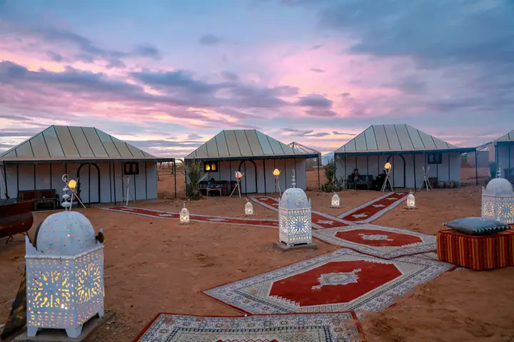 Tents of a luxury camp in Merzouga at sunset