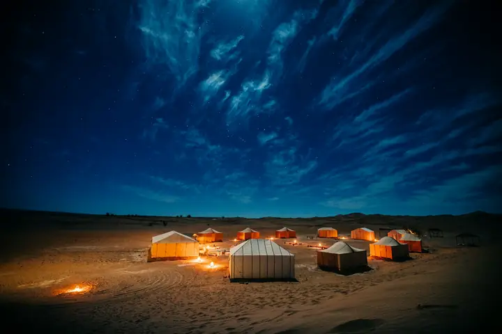 Camp lit up beneath the Saharan night sky